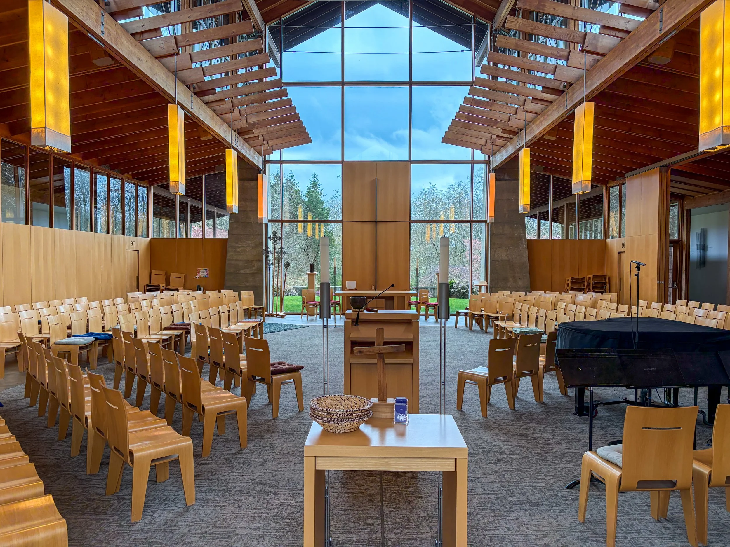 Interior of Grace Episcopal Church on Bainbridge Island, a modern timber-framed sanctuary with vaulted ceilings and a great gable window behind the altar